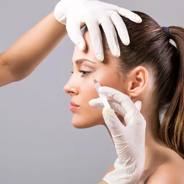 Injector marking a patient’s forehead before a wrinkle-relaxer treatment