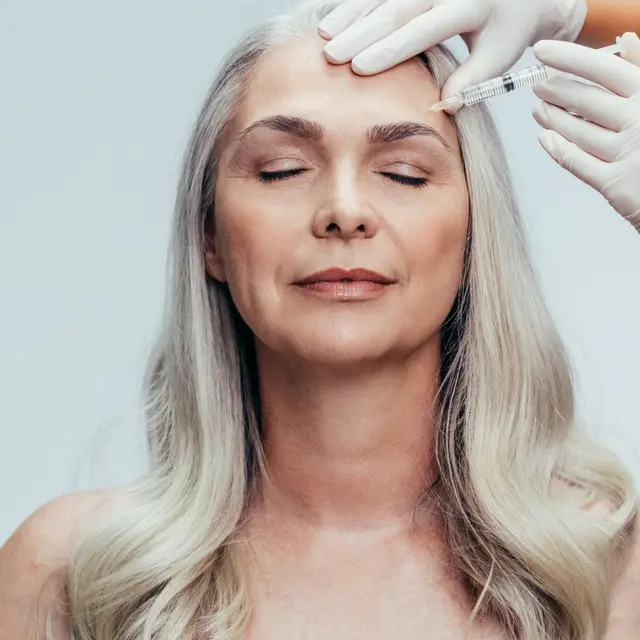 Patient receiving a cosmetic injection near the brow