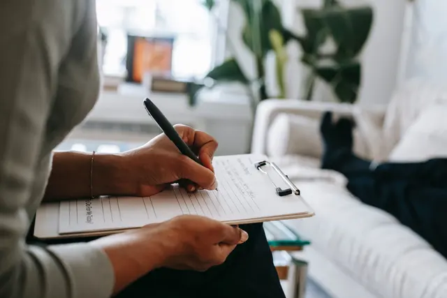 Clinician taking notes during a patient consultation