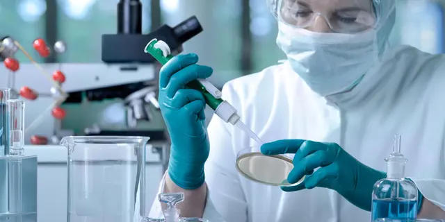 Lab specialist examining a slide under a microscope