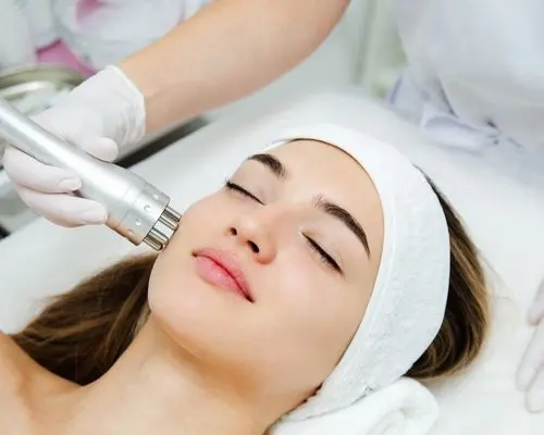 Esthetician using an ultrasonic device during a facial
