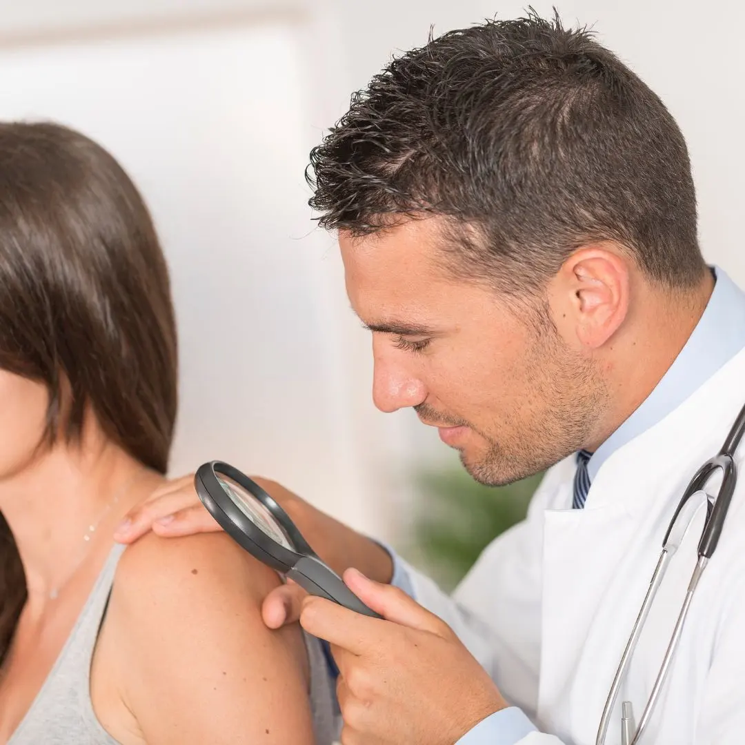 Provider examining a mole on a patient’s shoulder